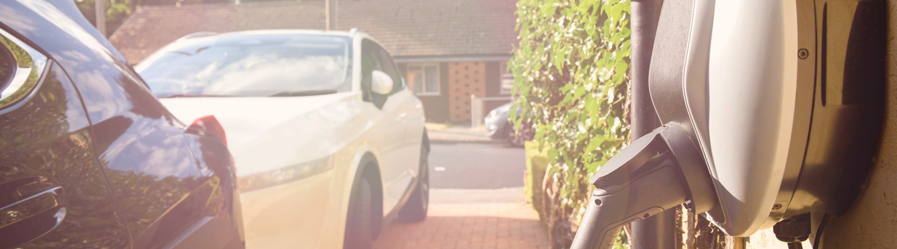 car parked on driveway plugged into wall socket