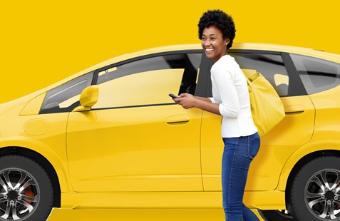 Woman gets into yellow car