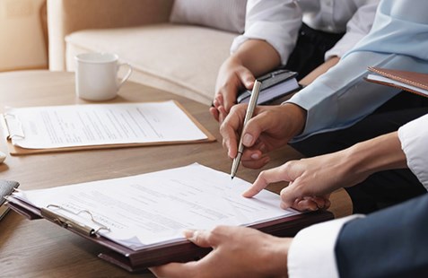 two people at table with paperwork