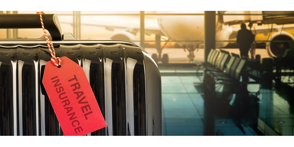 Black suitcase in an airport with a red travel insurance tag