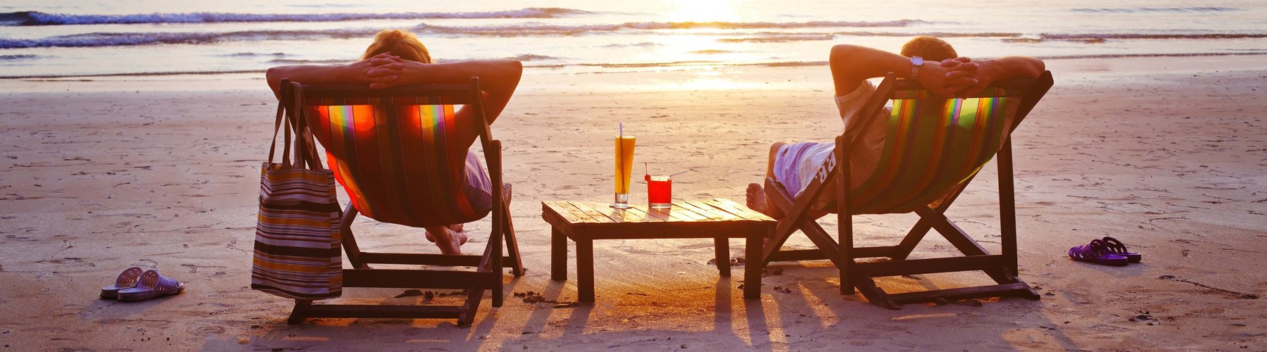 A couple sat on deck chairs on the beach