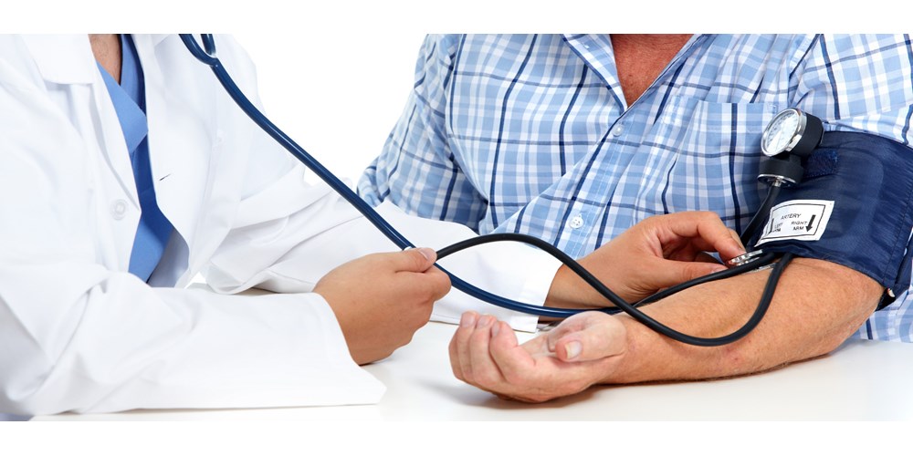 doctor checking male patients blood pressure 