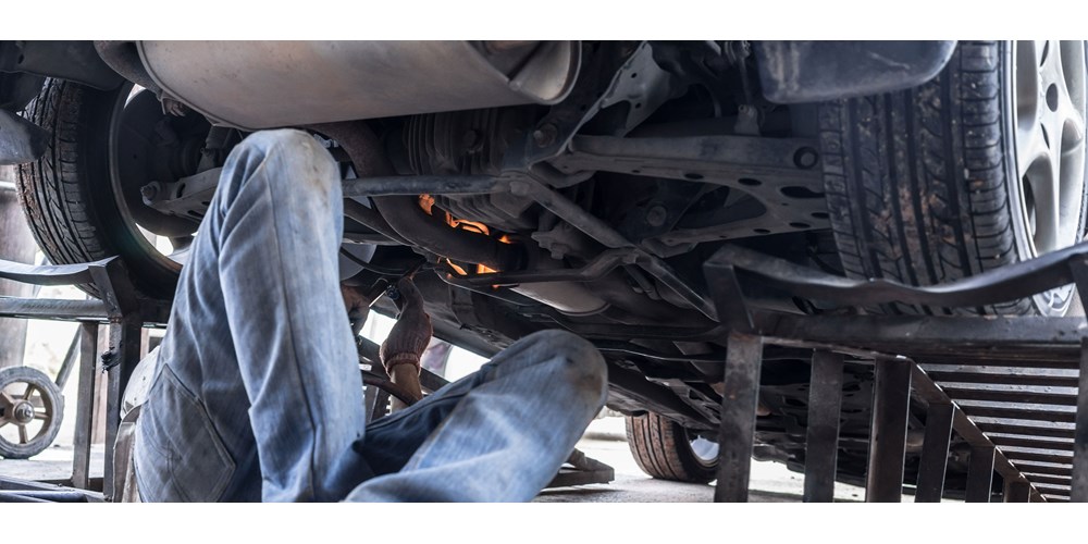 mechanic repairing car with green car parts