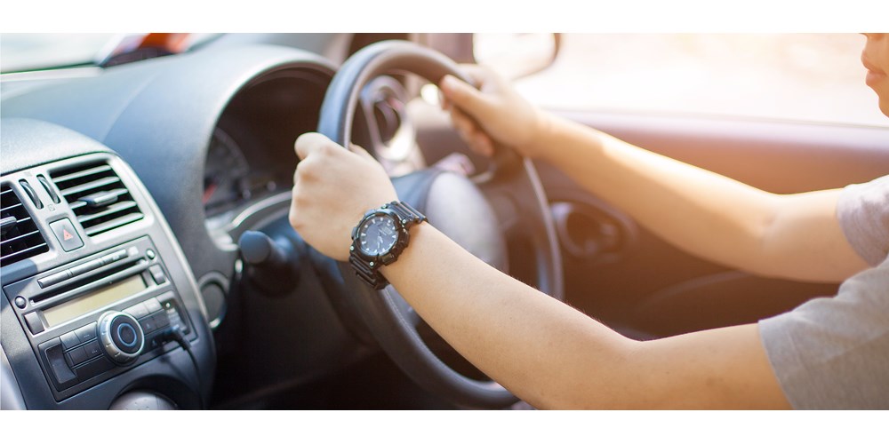 Woman's hands on the wheel of a car