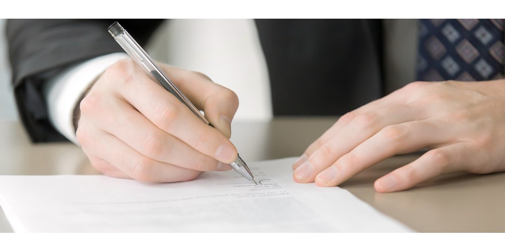 Man in a suit signing document