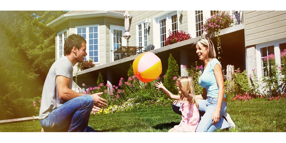 Smiling family in front of their home