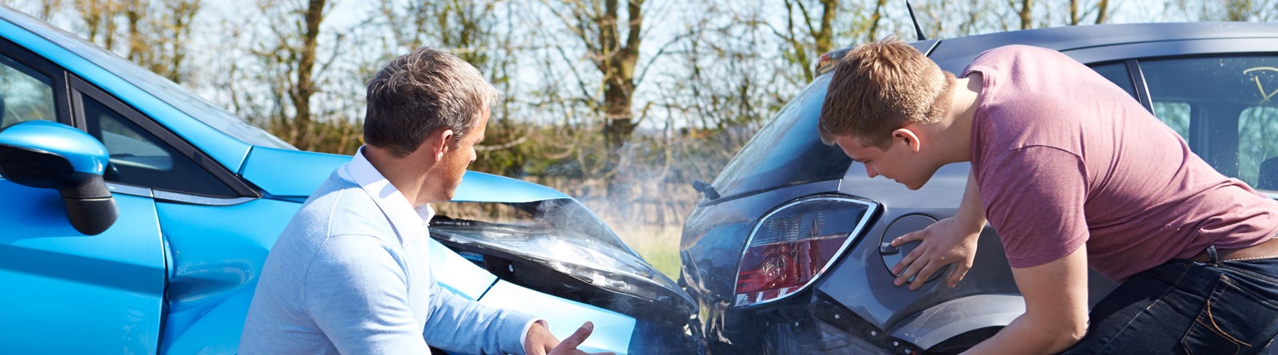 Two men looking at cars after collision