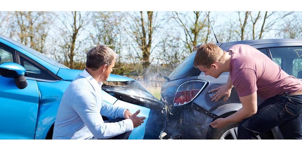 Two men looking at cars after collision