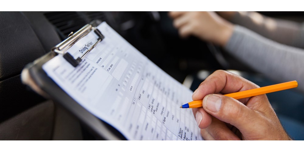 Male hand filling out a driving test form