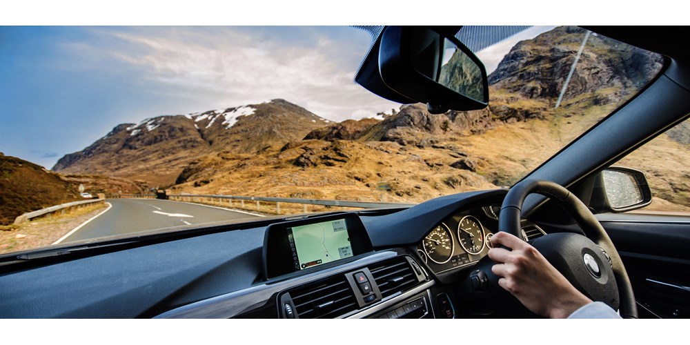 Man driving a car on a scenic road