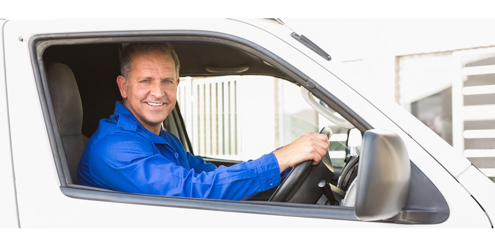 Smiling man driving a white van