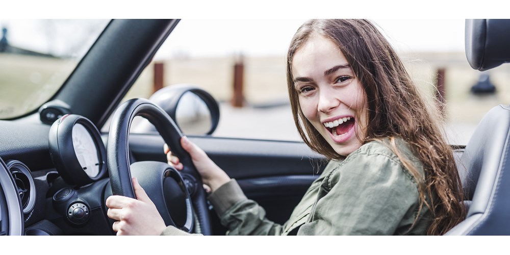Young woman smiling in car