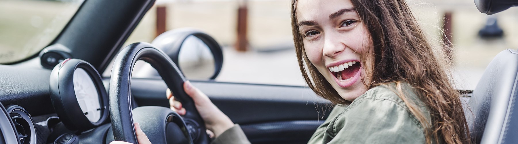 Young woman smiling in car