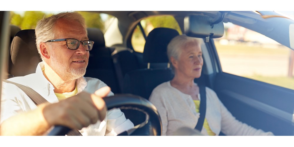 Older couple in car with male driver wearing glasses