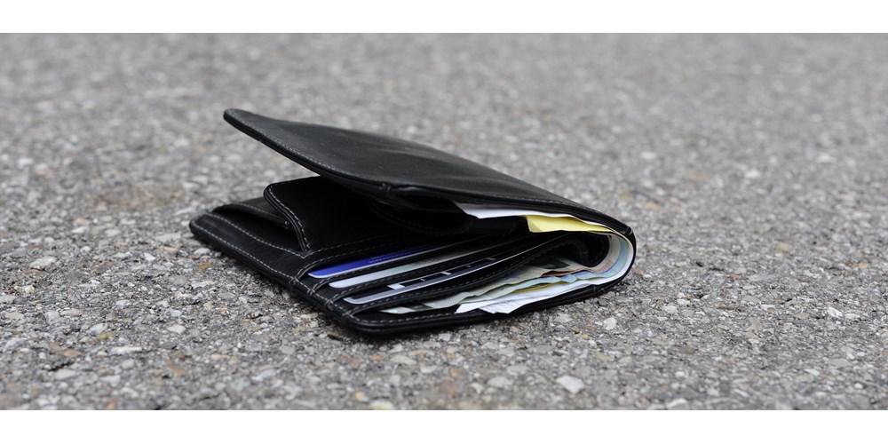 Black leather wallet on gravel floor