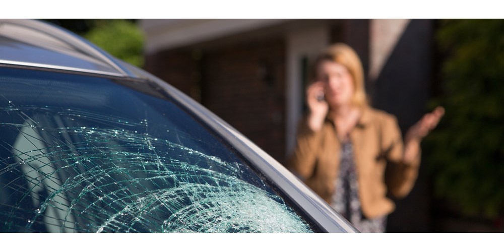 Broken car windscreen and woman on the phone 