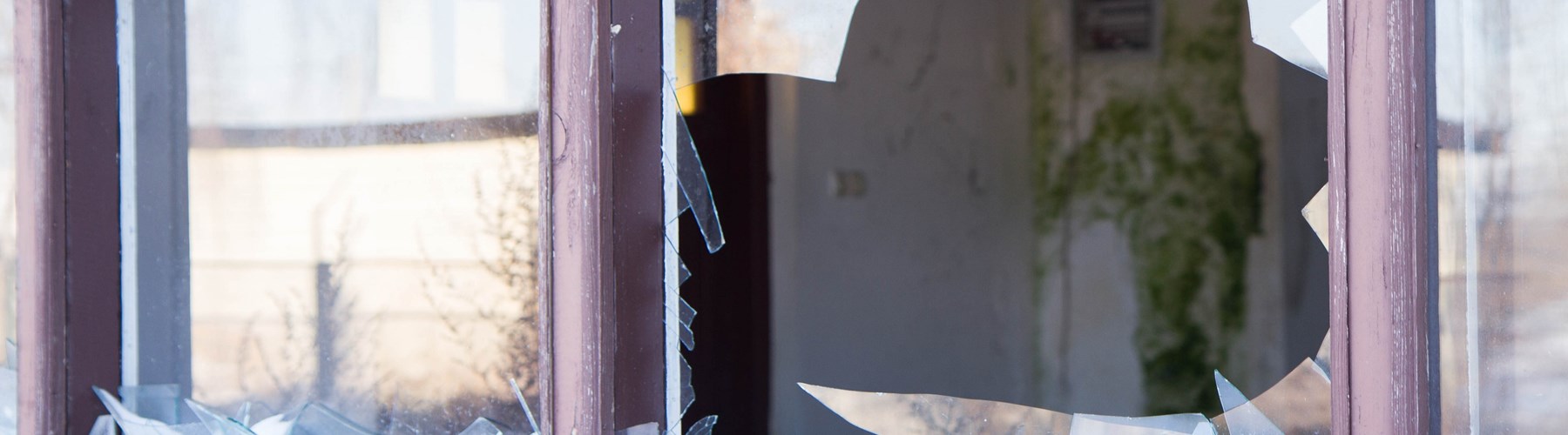 House window smashed with broken glass 