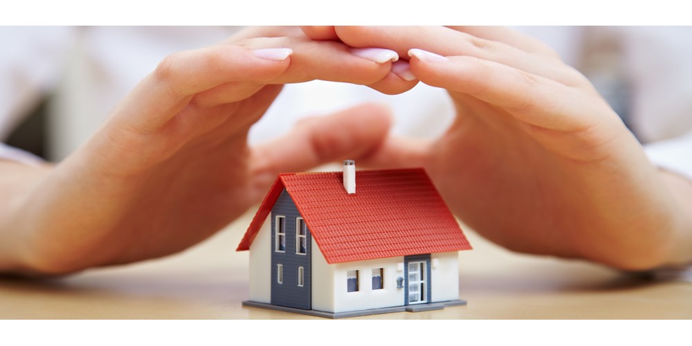 Woman's hand protecting a house