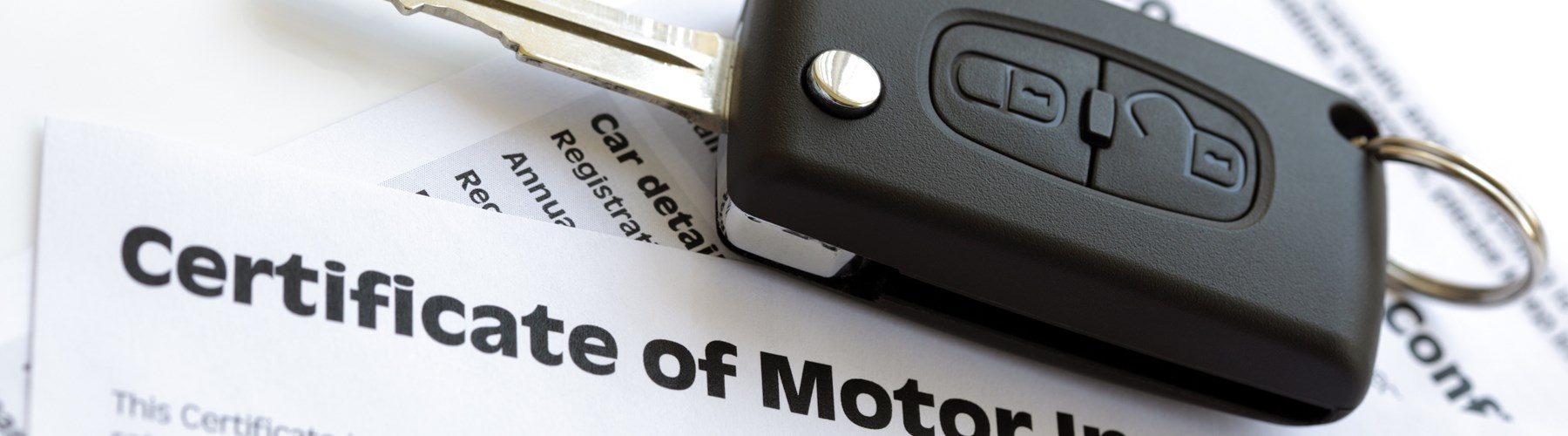 Car key on certificate of motor insurance