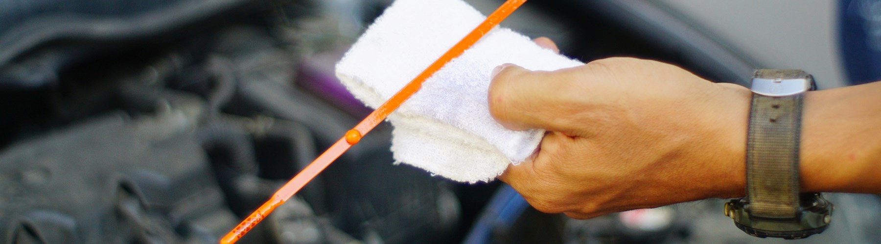Man's hand checking car oil level