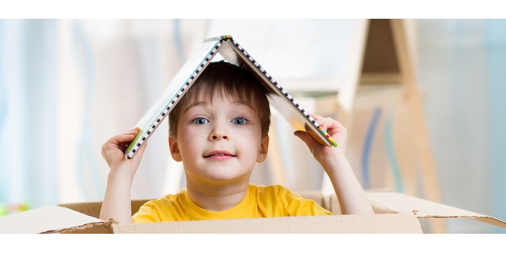 Child playing in box at home