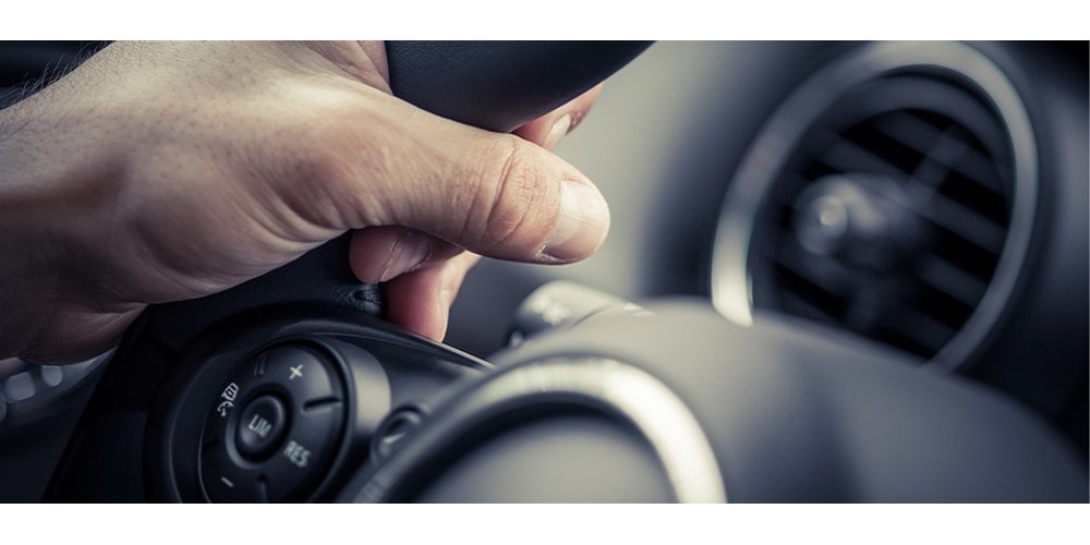 A man's hand on a steering wheel