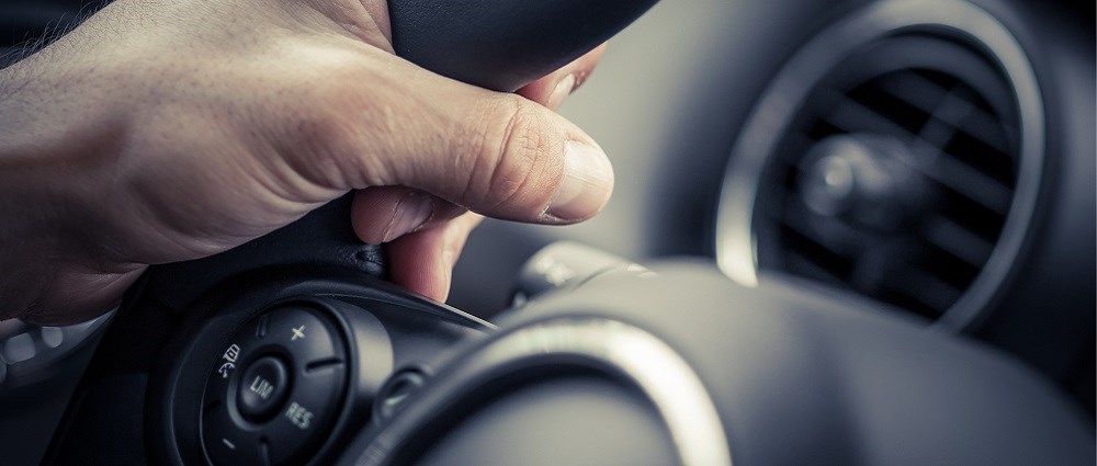 A man's hand on a steering wheel