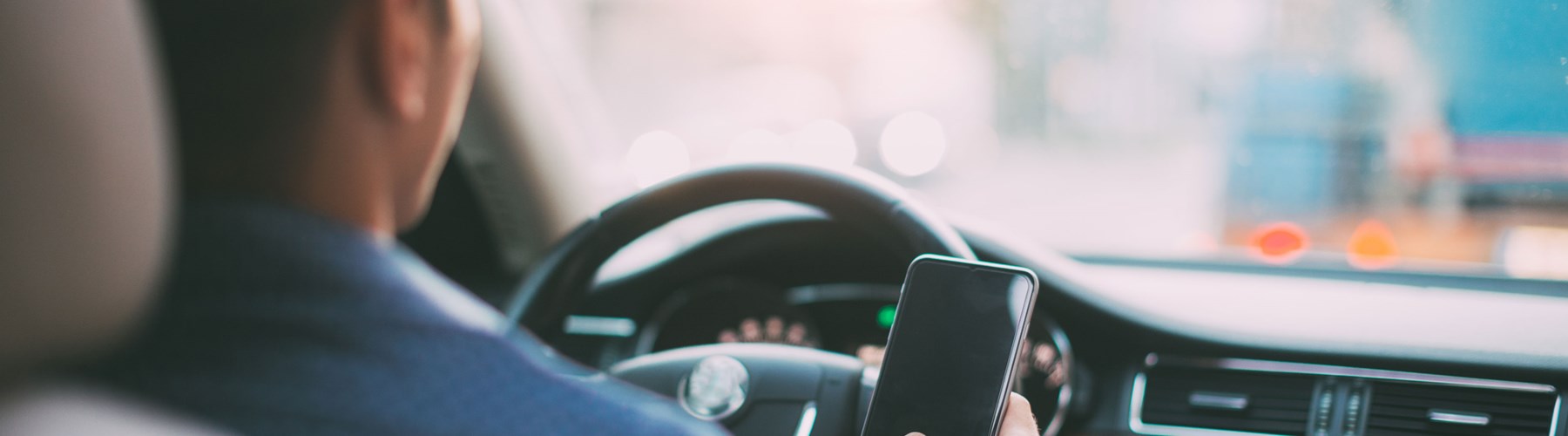 Man driving his car with mobile phone in hand