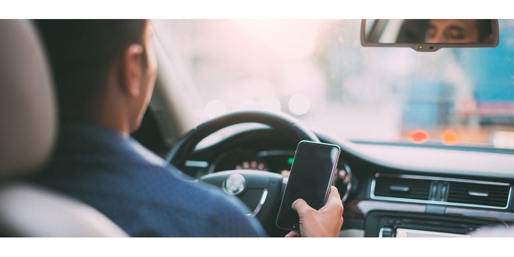 Man driving his car with mobile phone in hand