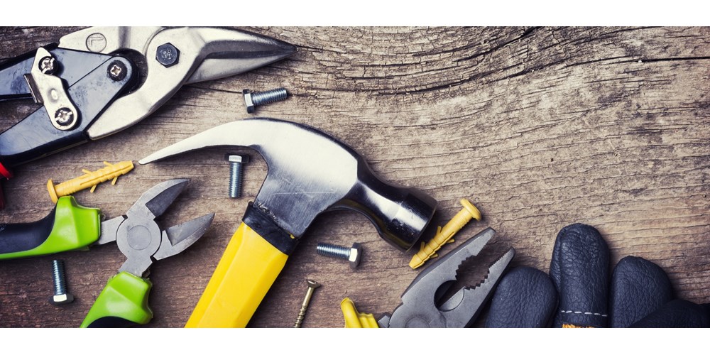 Handyman tools scattered across wood flooring 