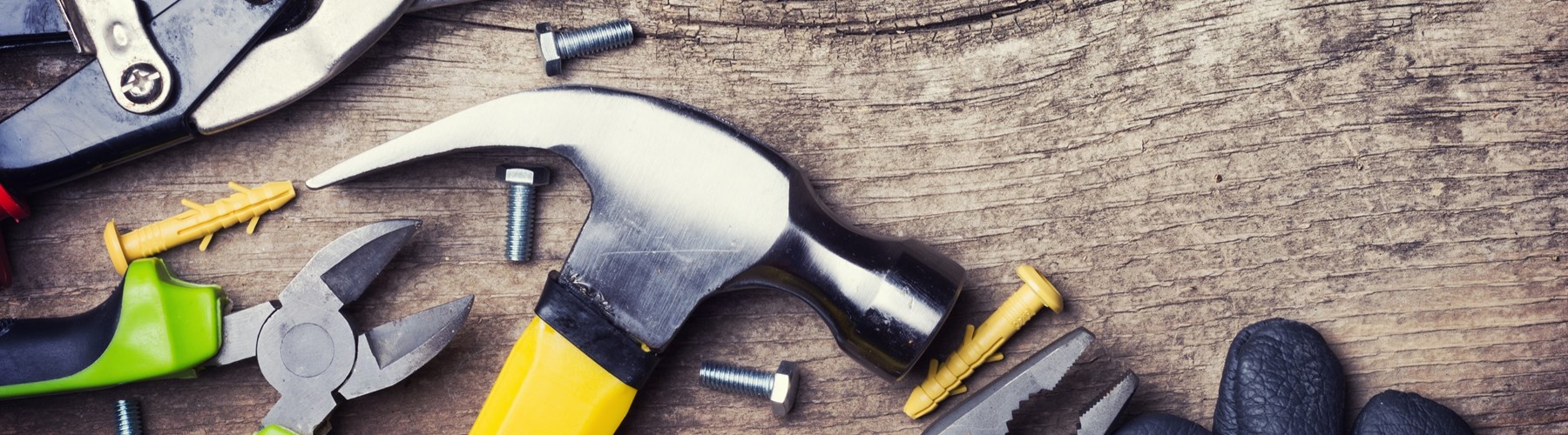 Handyman tools scattered across wood flooring 
