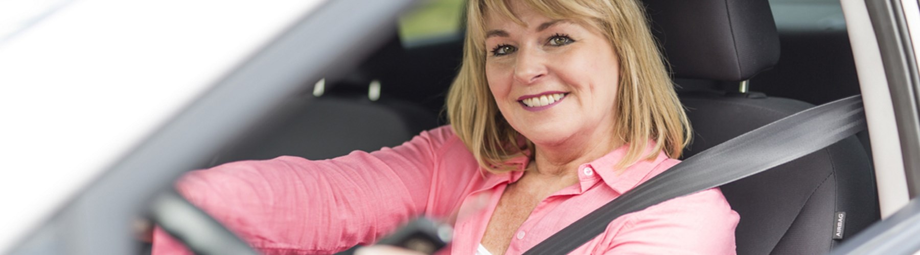 lady in drivers seat smiling at camera
