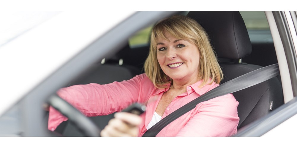 lady in drivers seat smiling at camera