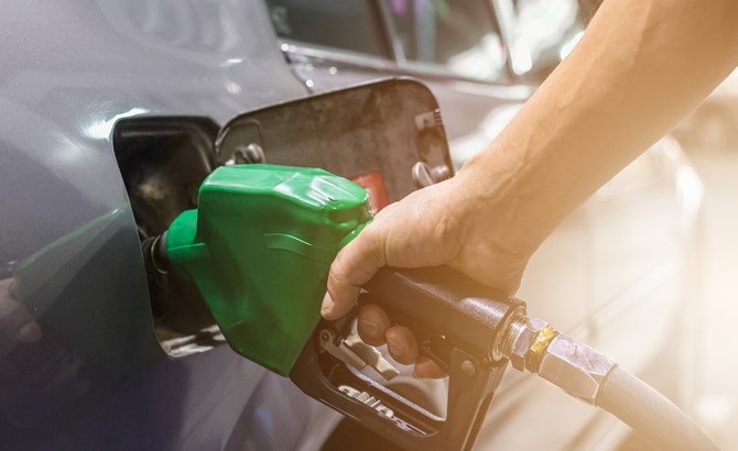 Man fueling silver car