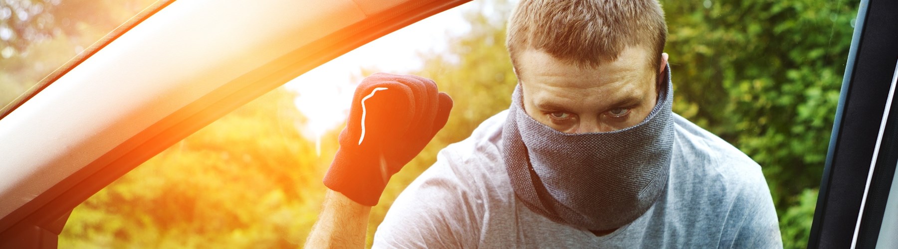 Man with mask approaching car with flashlight