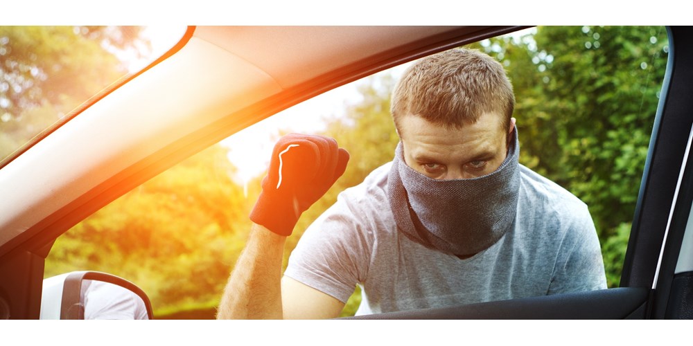 Man with mask approaching car with flashlight