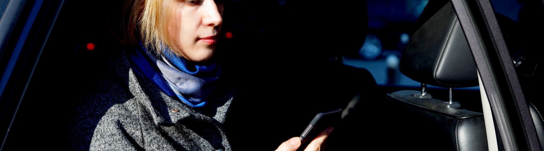 women in parked car on phone