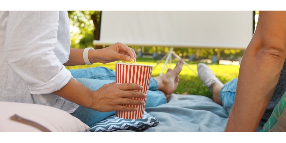 Couple getting ready to watch film outdoors