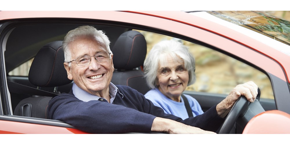 Older couple in an orange car