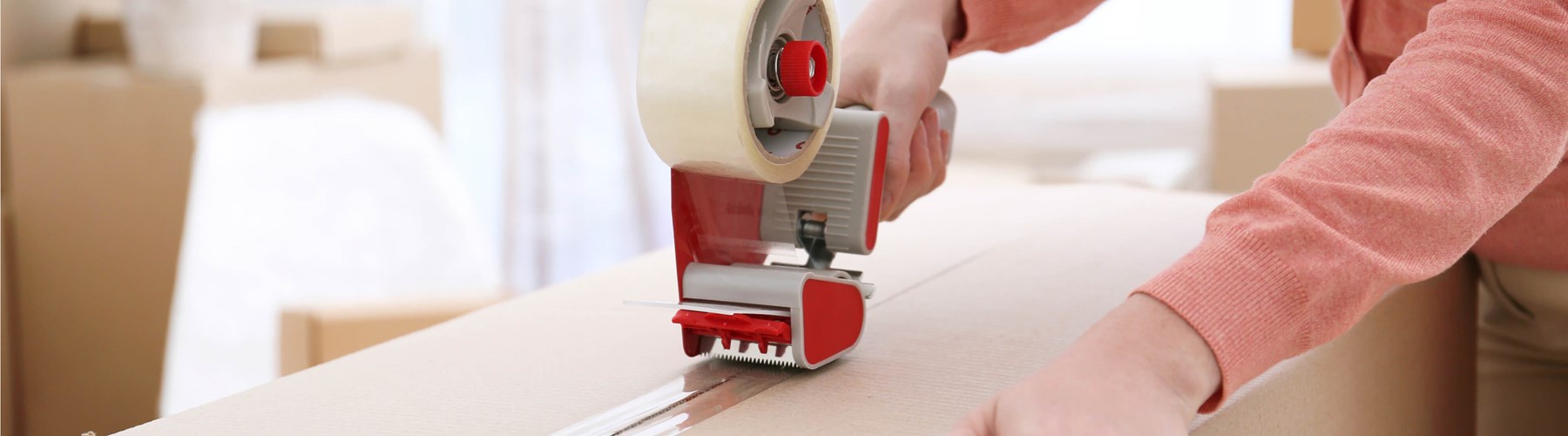 A box being taped up using sellotape dispenser