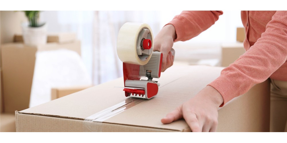 A box being taped up using sellotape dispenser