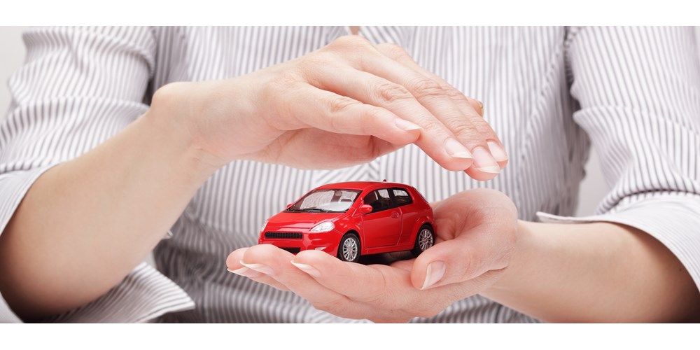 Red toy car held and covered by a woman's hands