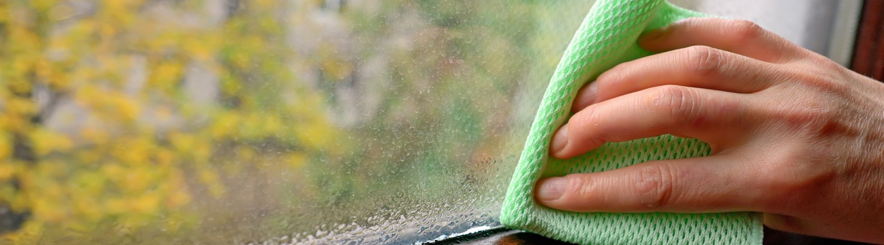 Man wiping condensation off windows