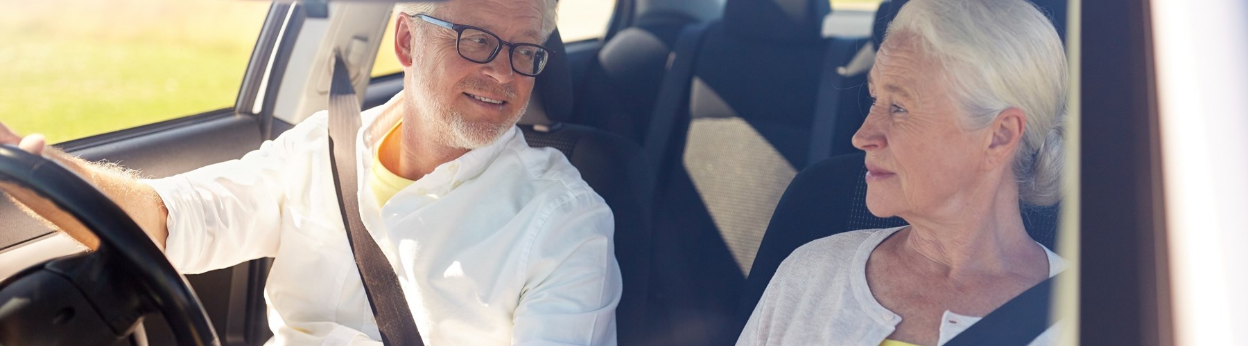 older couple smiling in car
