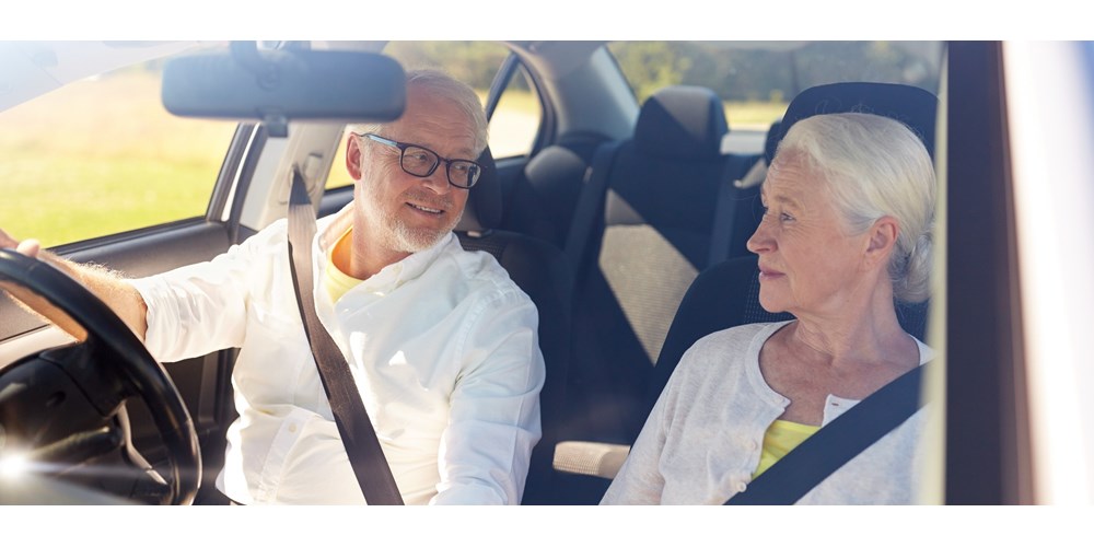 older couple smiling in car