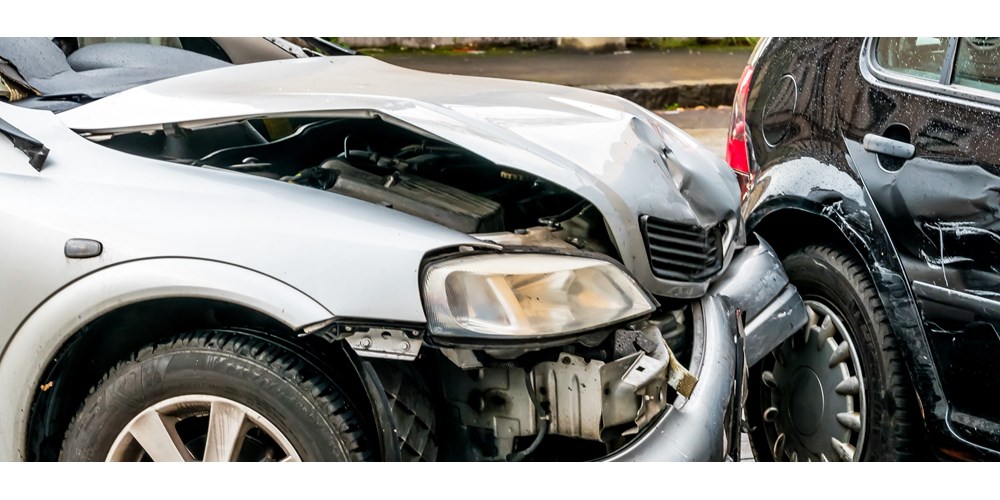 Silver car with frontal damage after crash