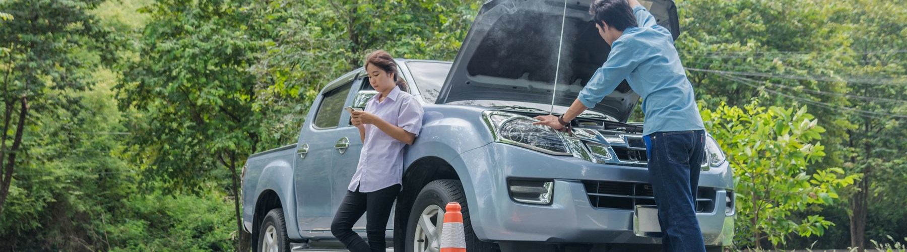 Couple with broken down car on the side of the road