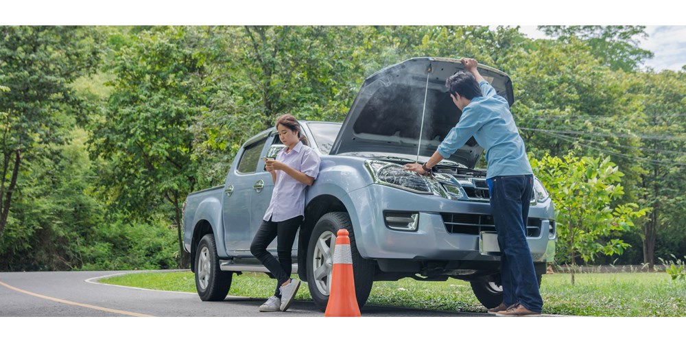 Couple with broken down car on the side of the road