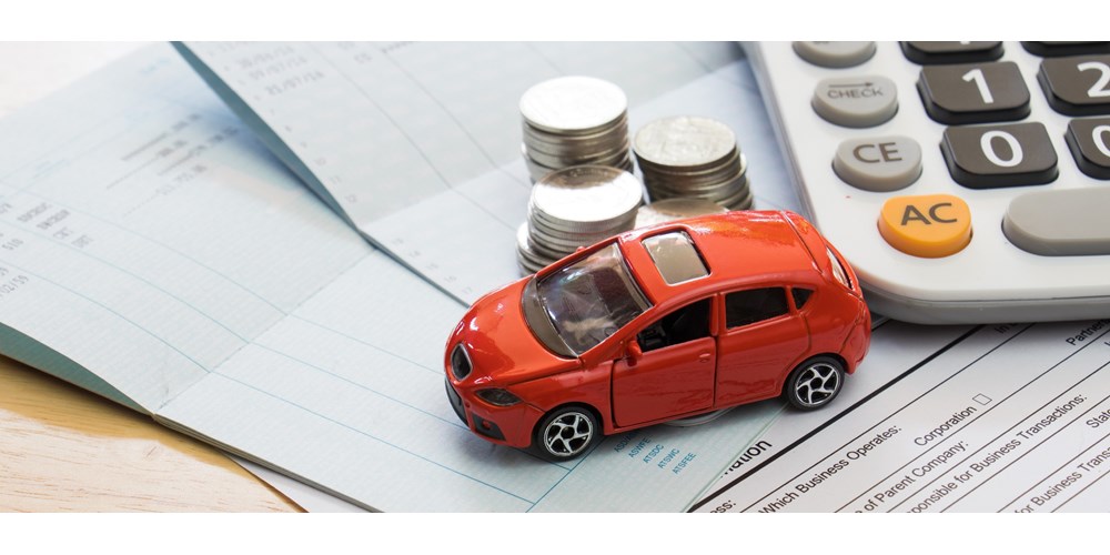Red toy car with calculator and coins on top of documents