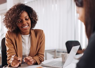 two women chatting at desk